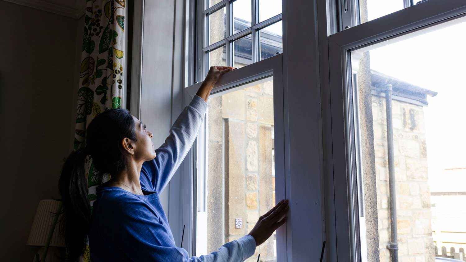 A woman closing the windows