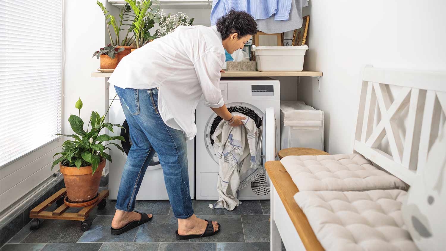 A woman putting clothes into a dryer