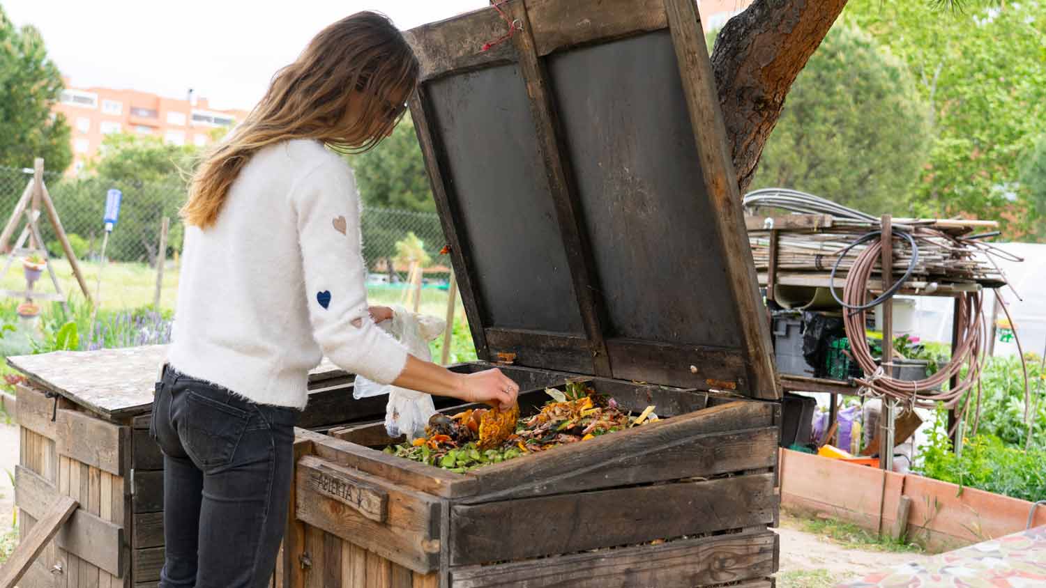 Woman composting food scraps in bin