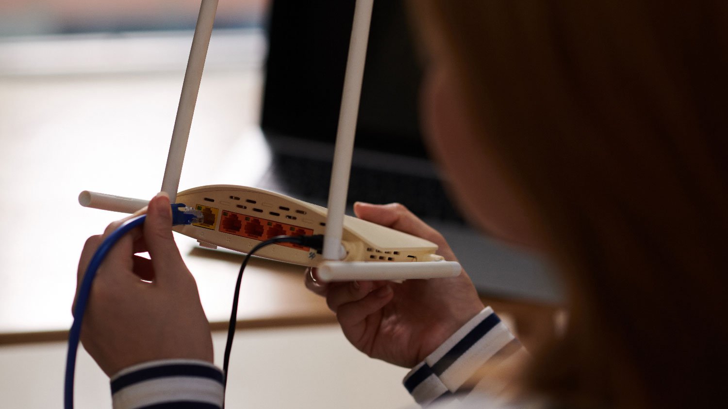 A woman configuring the settings of a modem