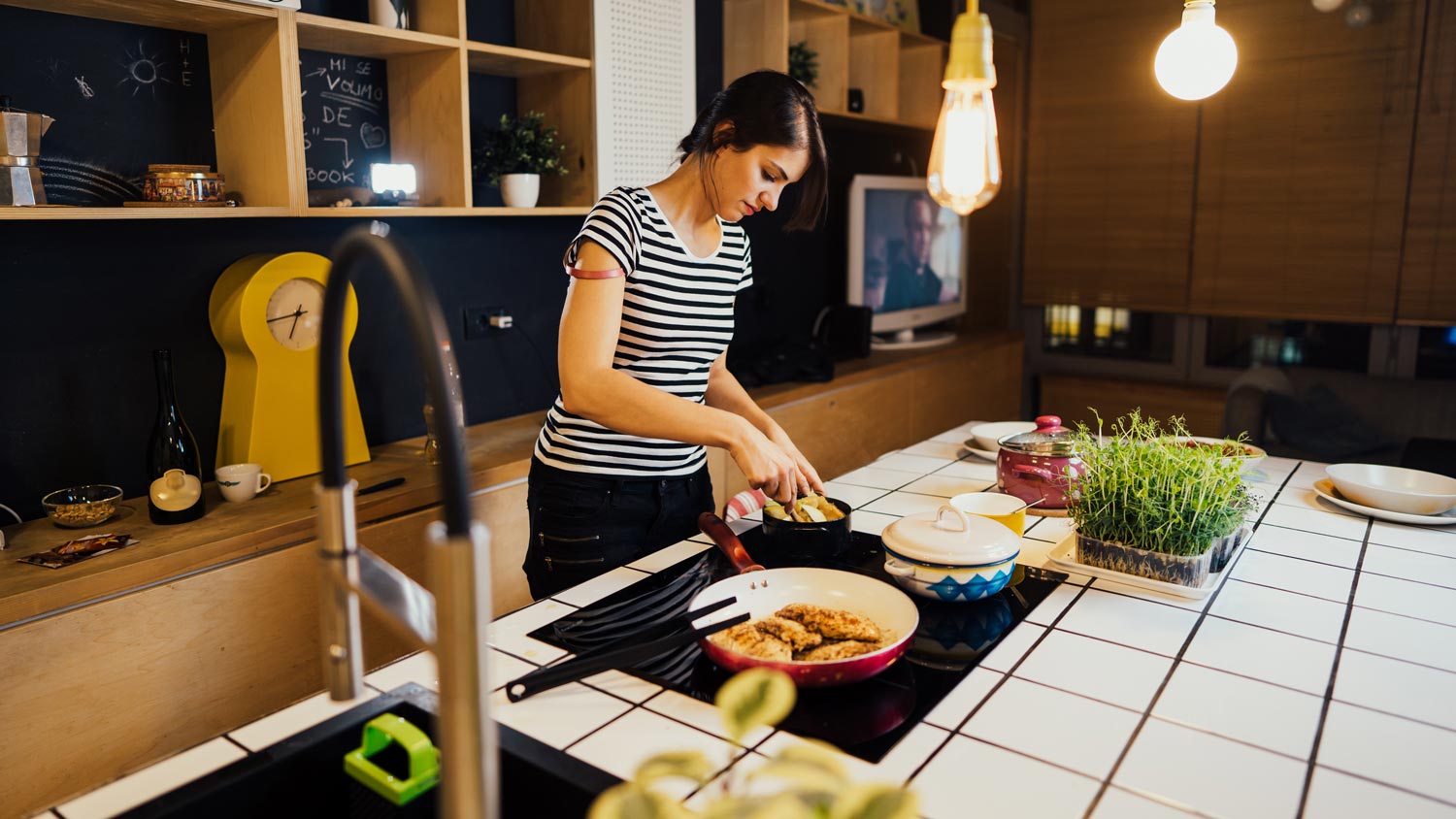 A woman cooking on a kitchen island