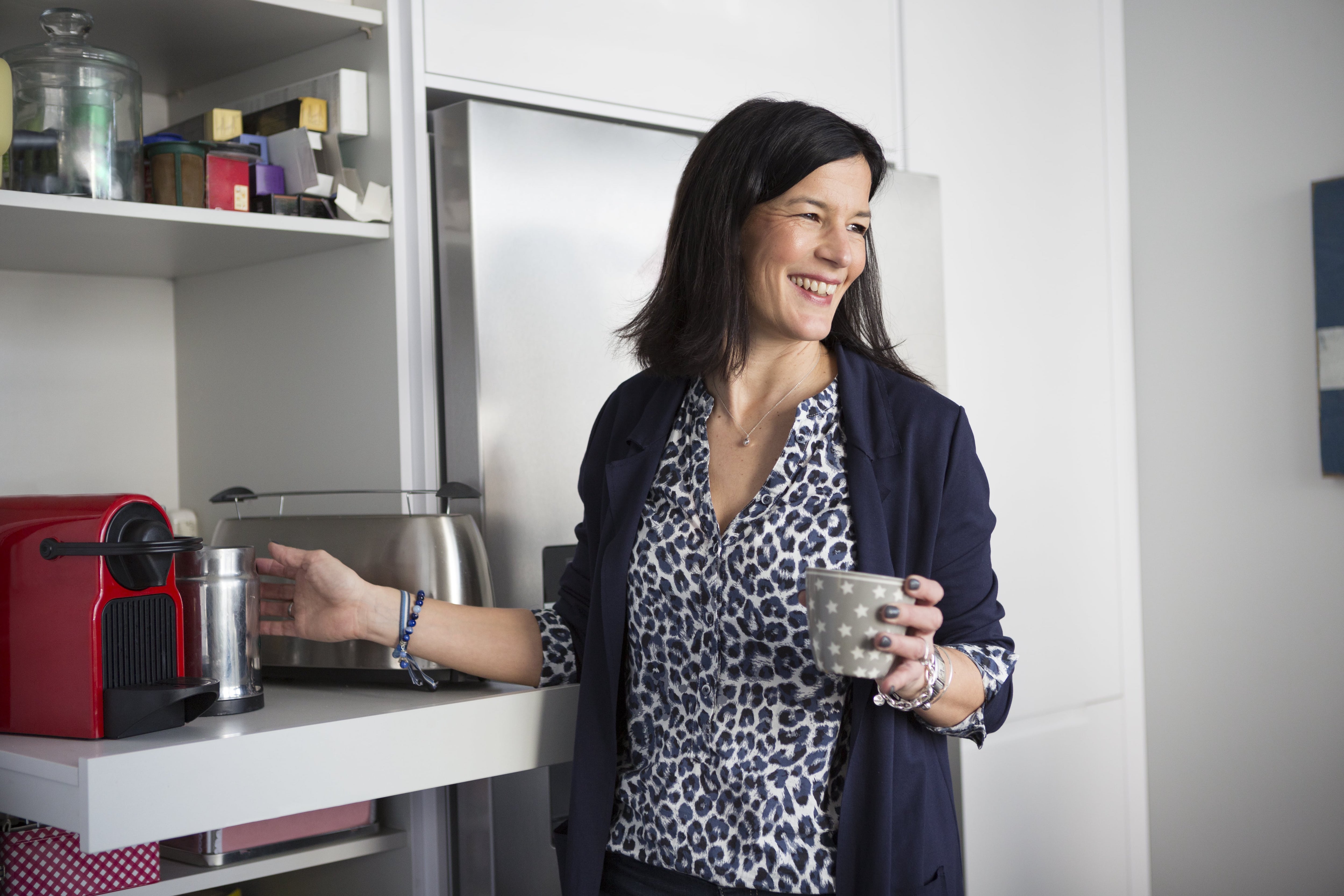 Woman using coffee machine on pull-out shelf