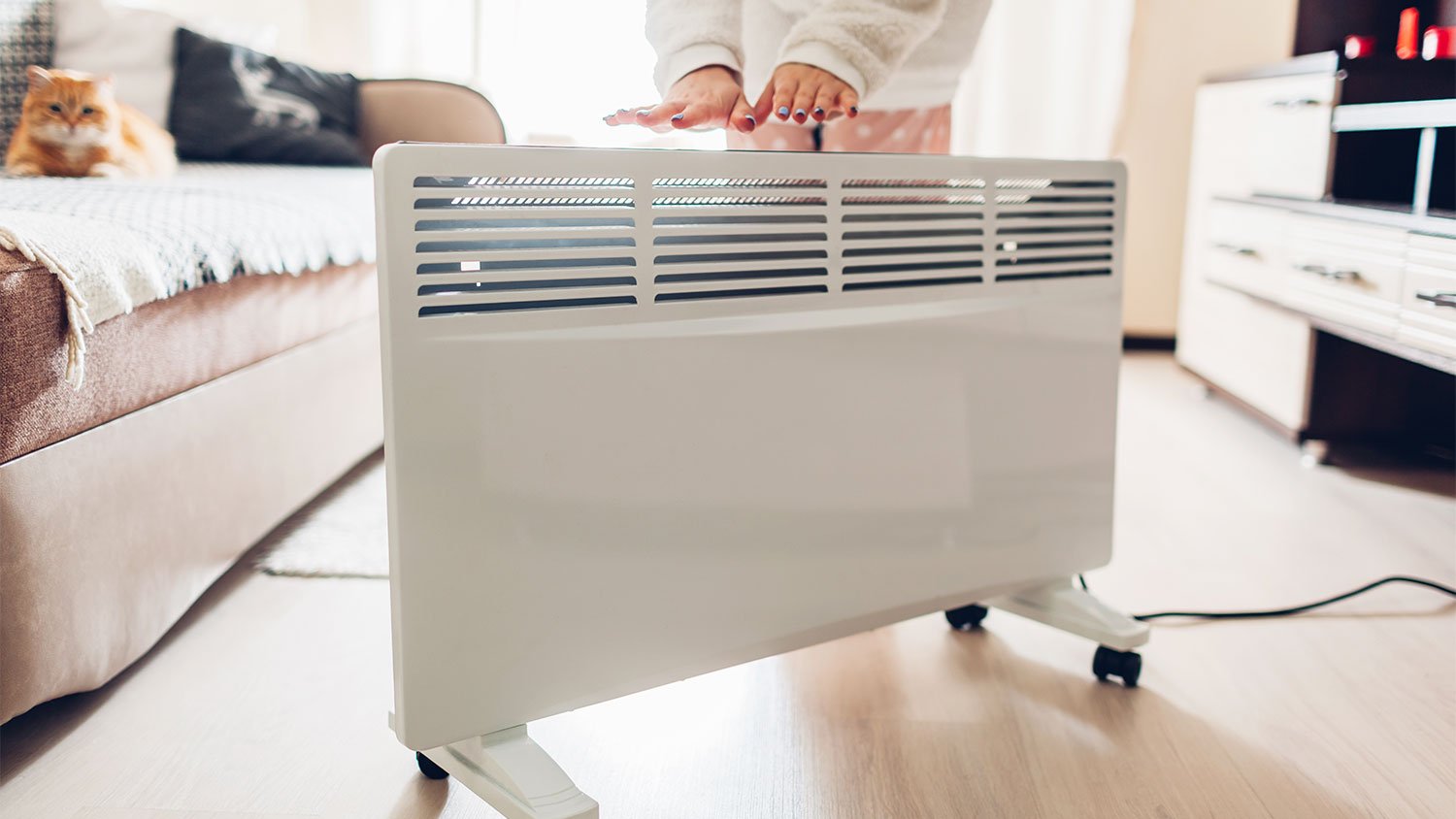 woman using electric heater at home