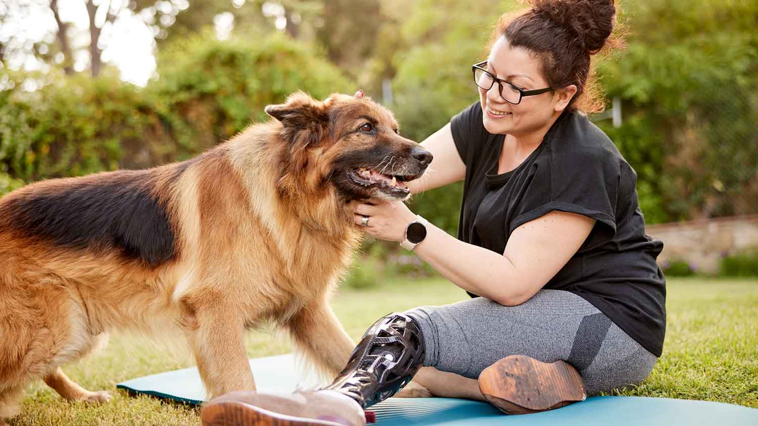 Woman in the yard enjoying time with her German Sheperd dog