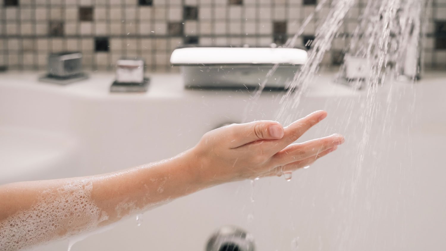 A woman feeling the water from the shower