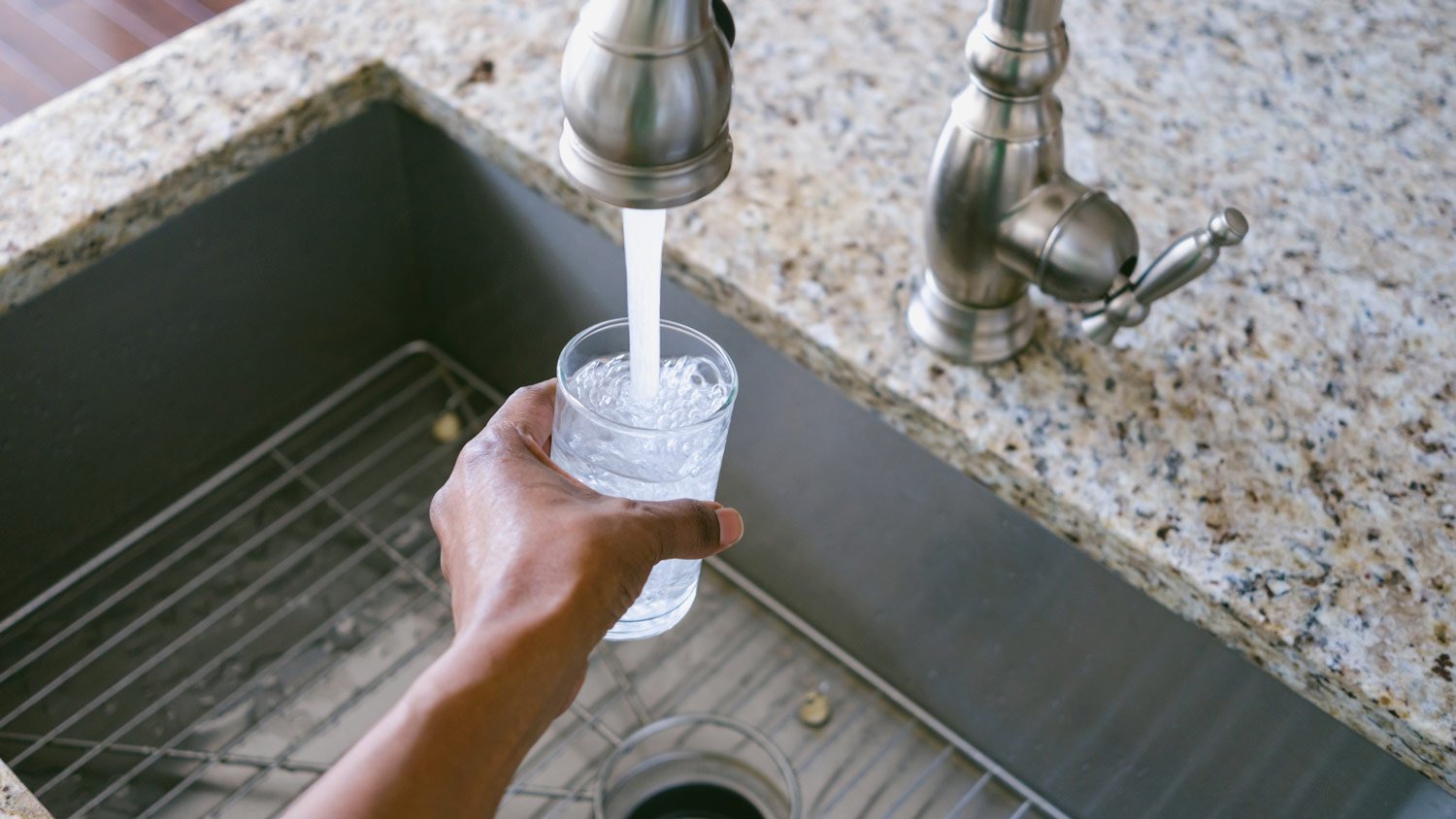 A woman filling a glass with tap water