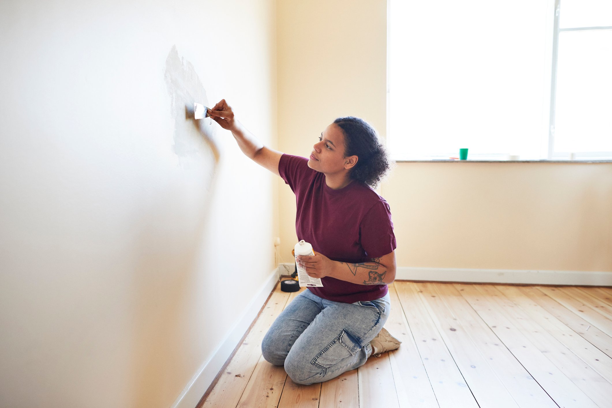 Woman patching up holes on the wall