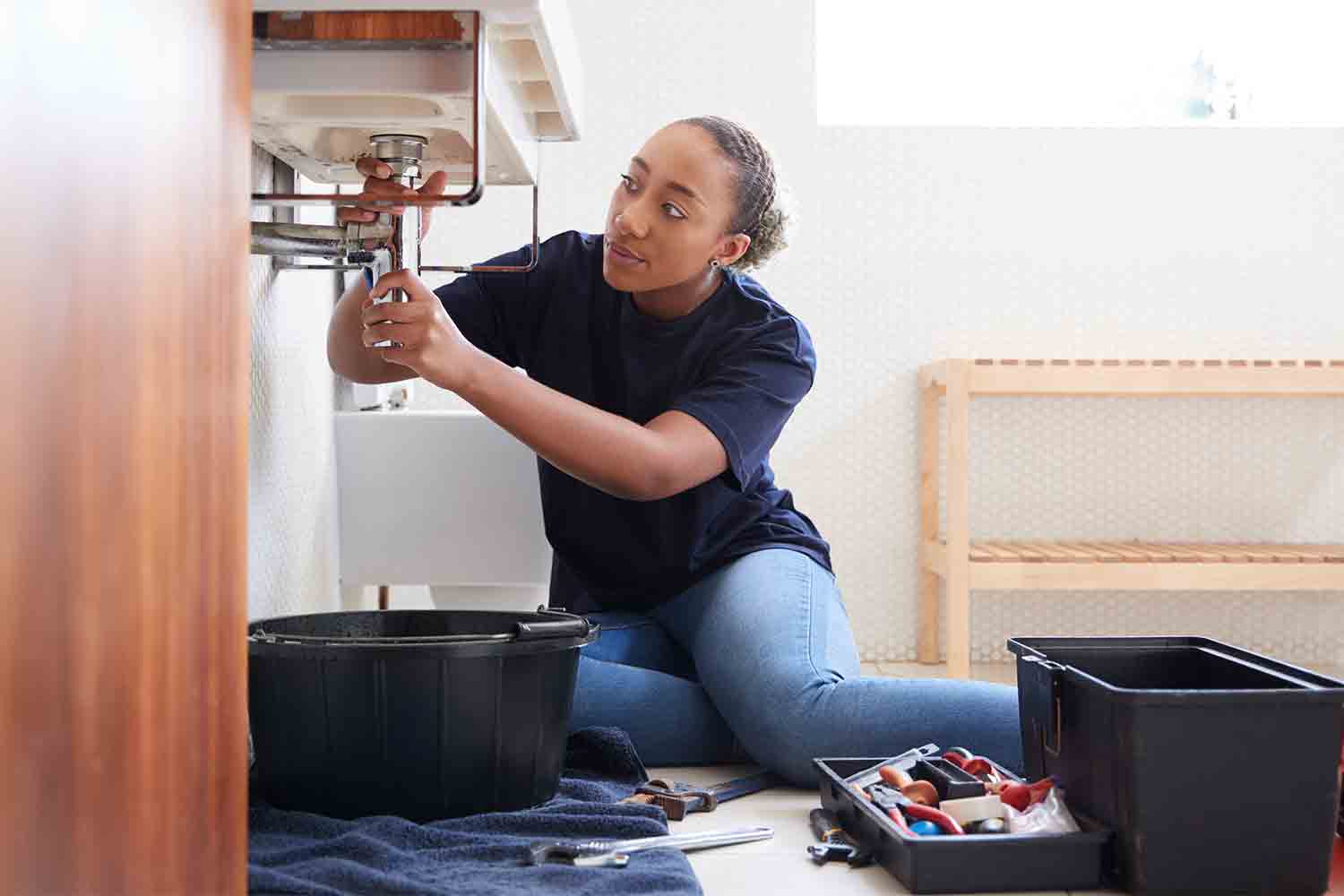 woman working on bathroom pluming