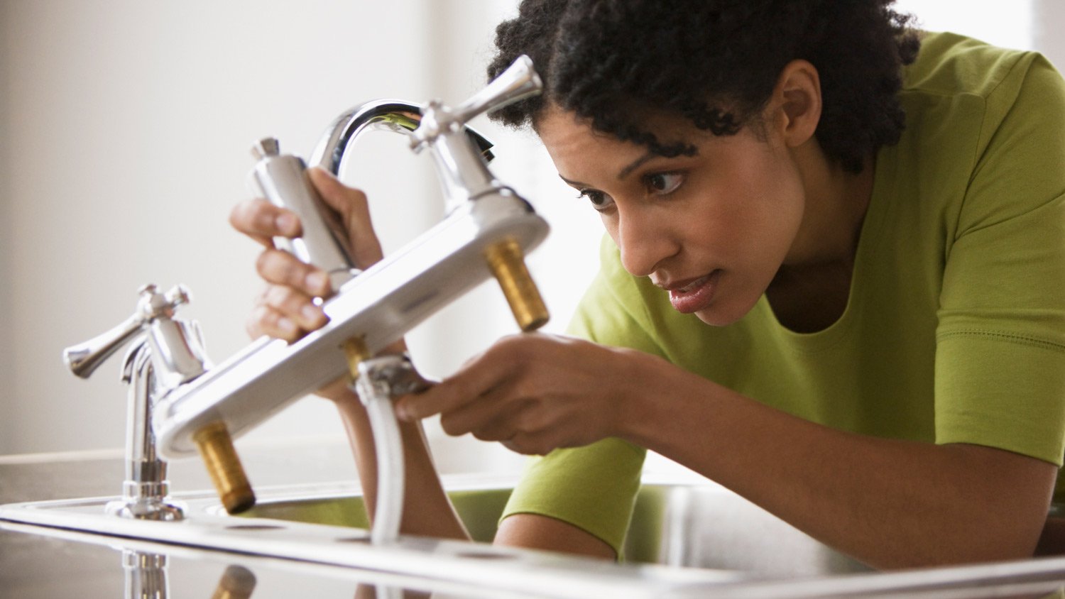 A woman repairing a faucet