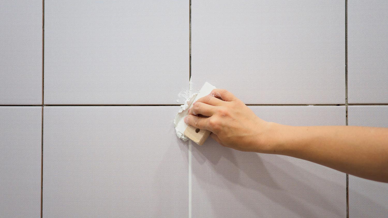 A woman grouting tiles