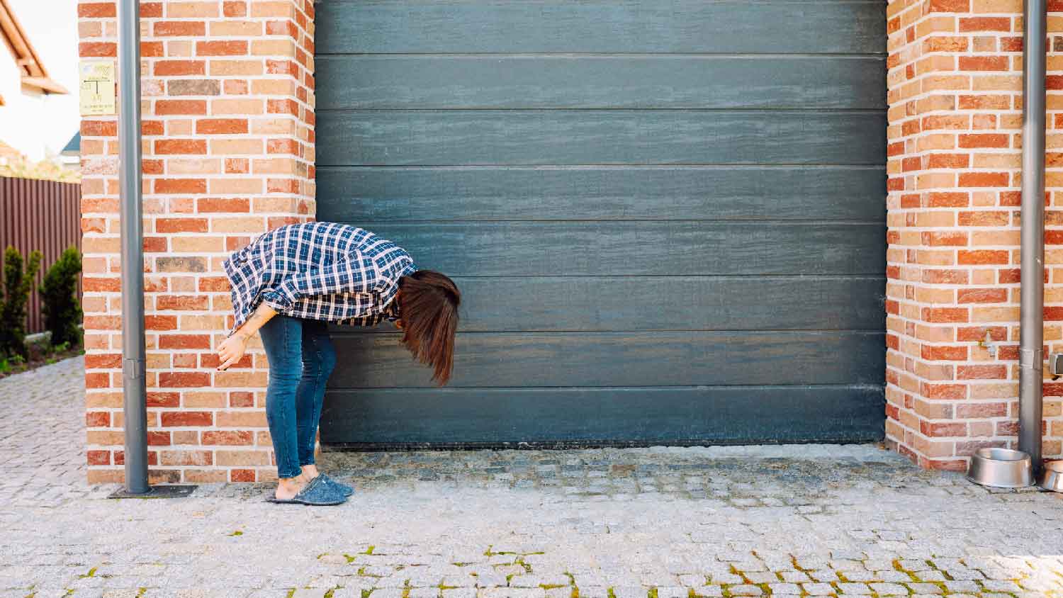 A woman inspecting a closed garage door