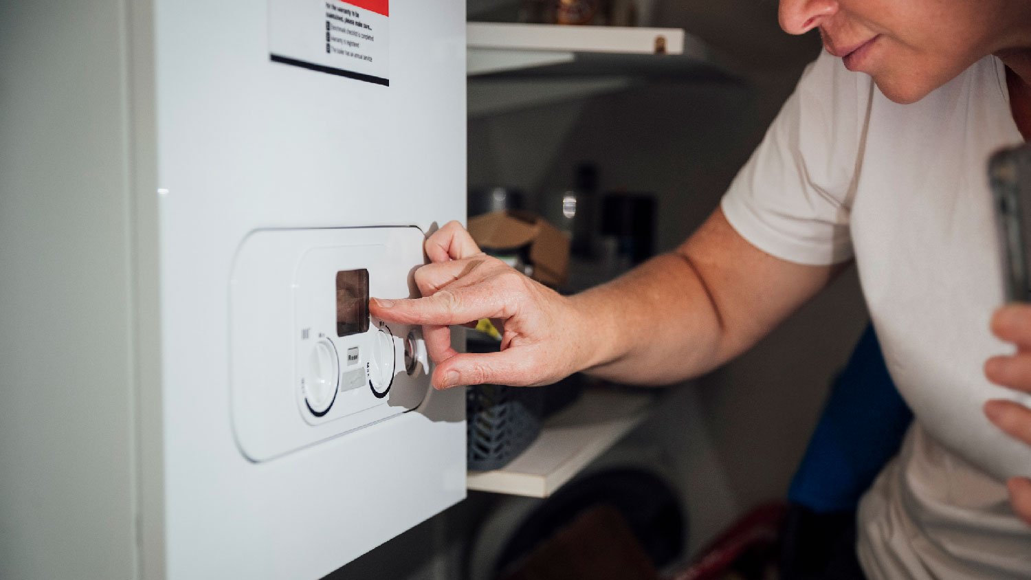 A woman inspecting the water heater