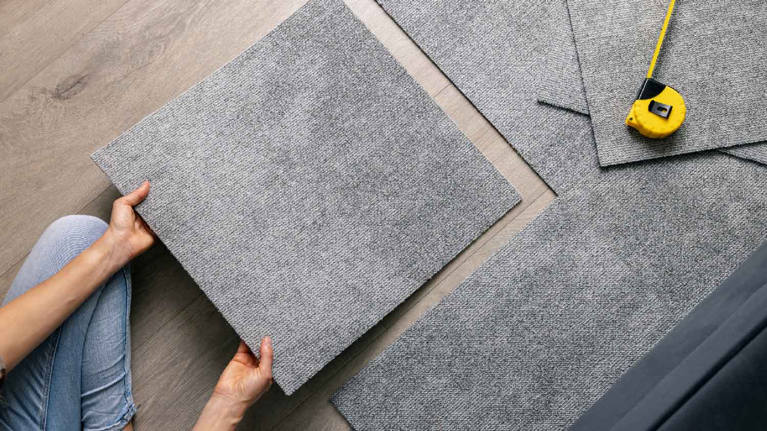 A woman installing carpet tiles