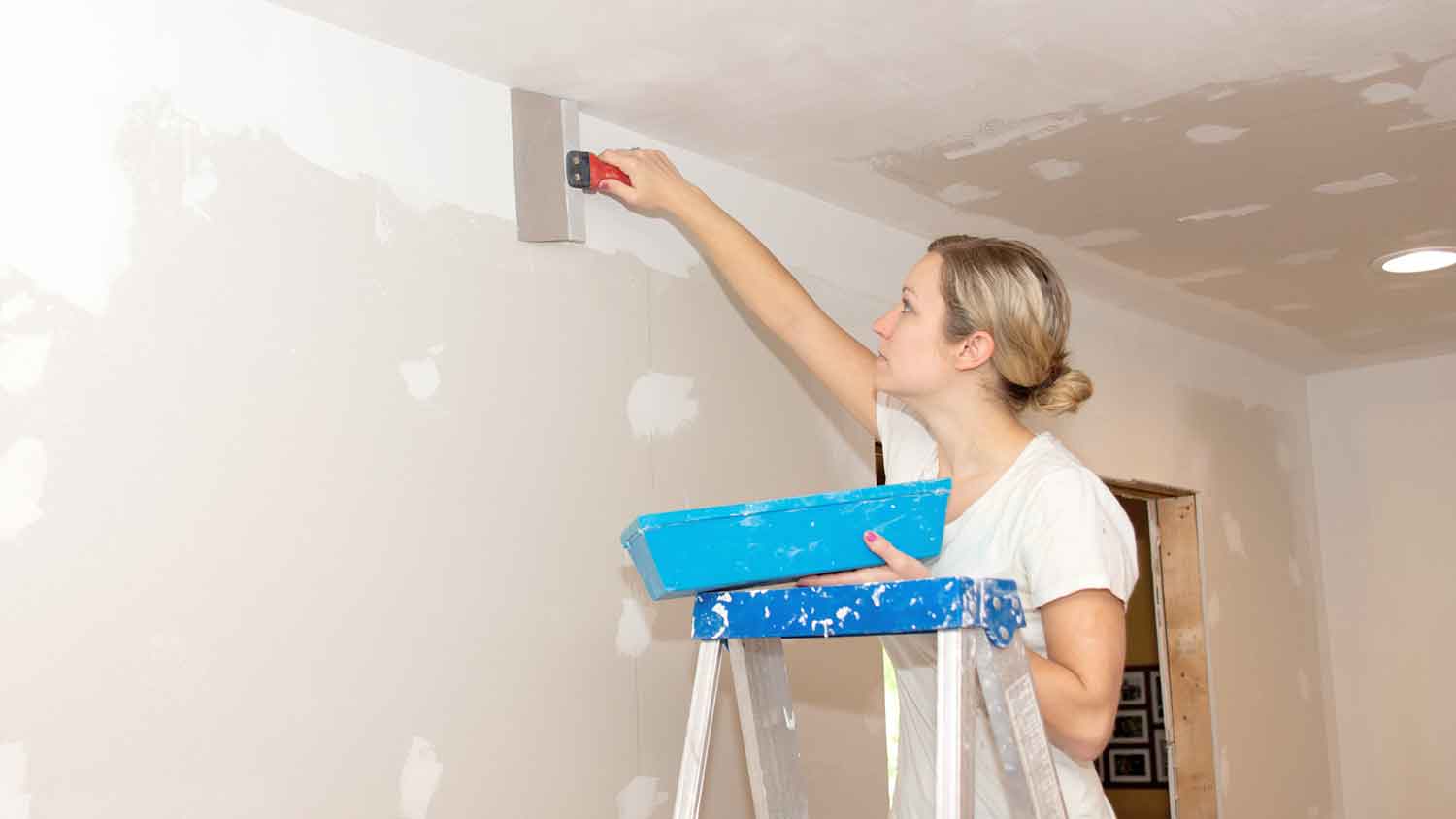 Woman applying drywall compound