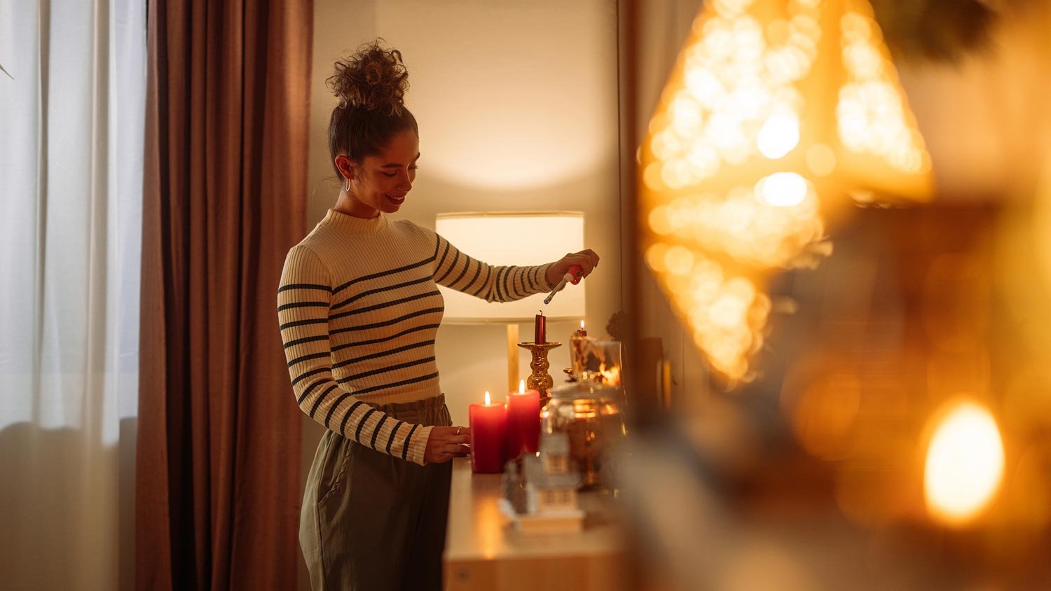 A woman lightning candles in her house