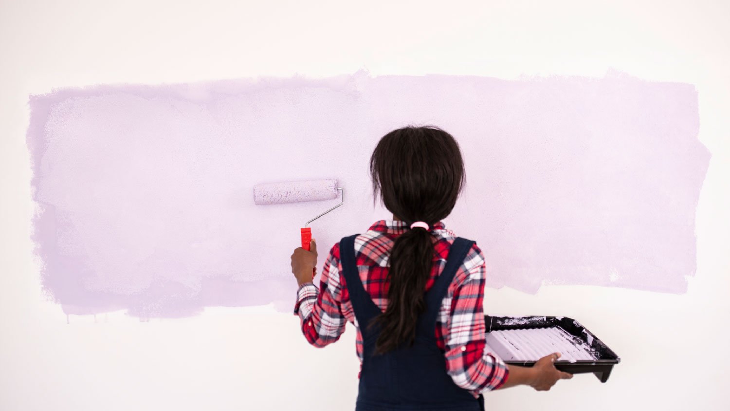 A woman limewashing a wall