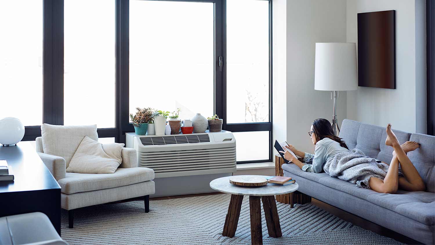 woman at home in living room with air conditioner