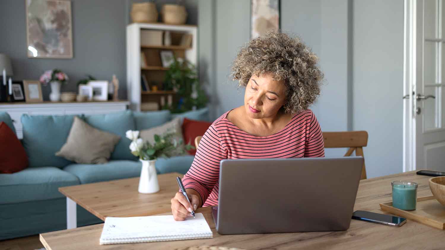 Woman in the living room taking notes