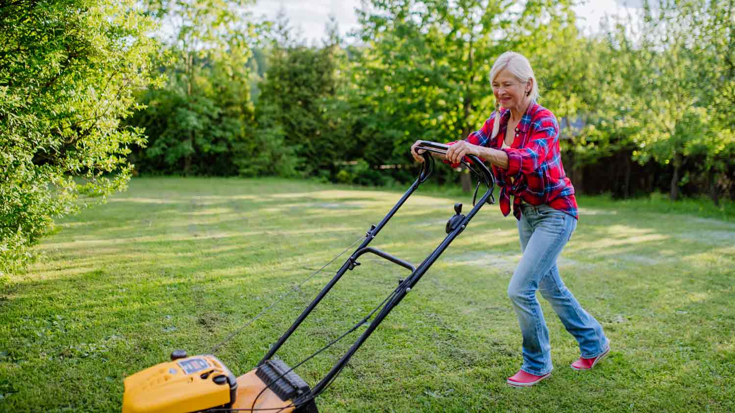 elderly woman mowing lawn