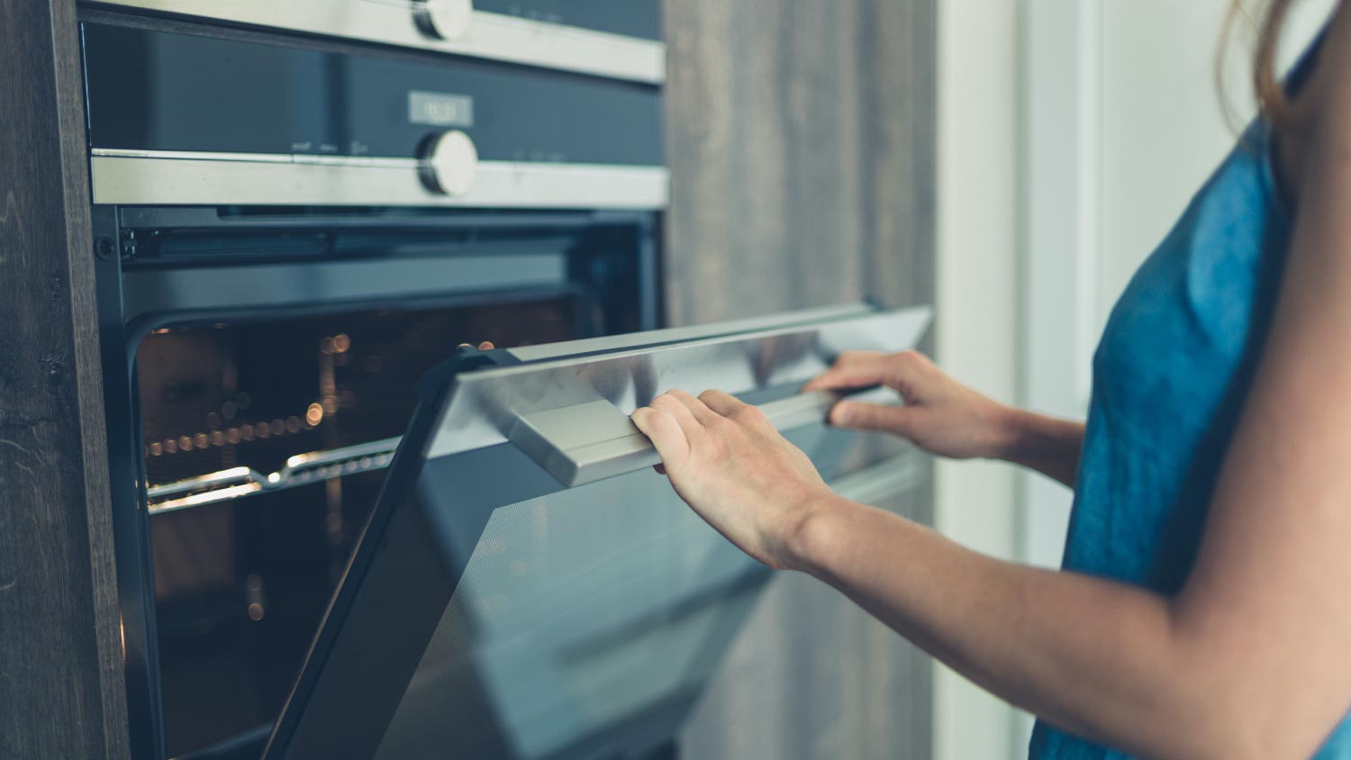 A woman opening the oven