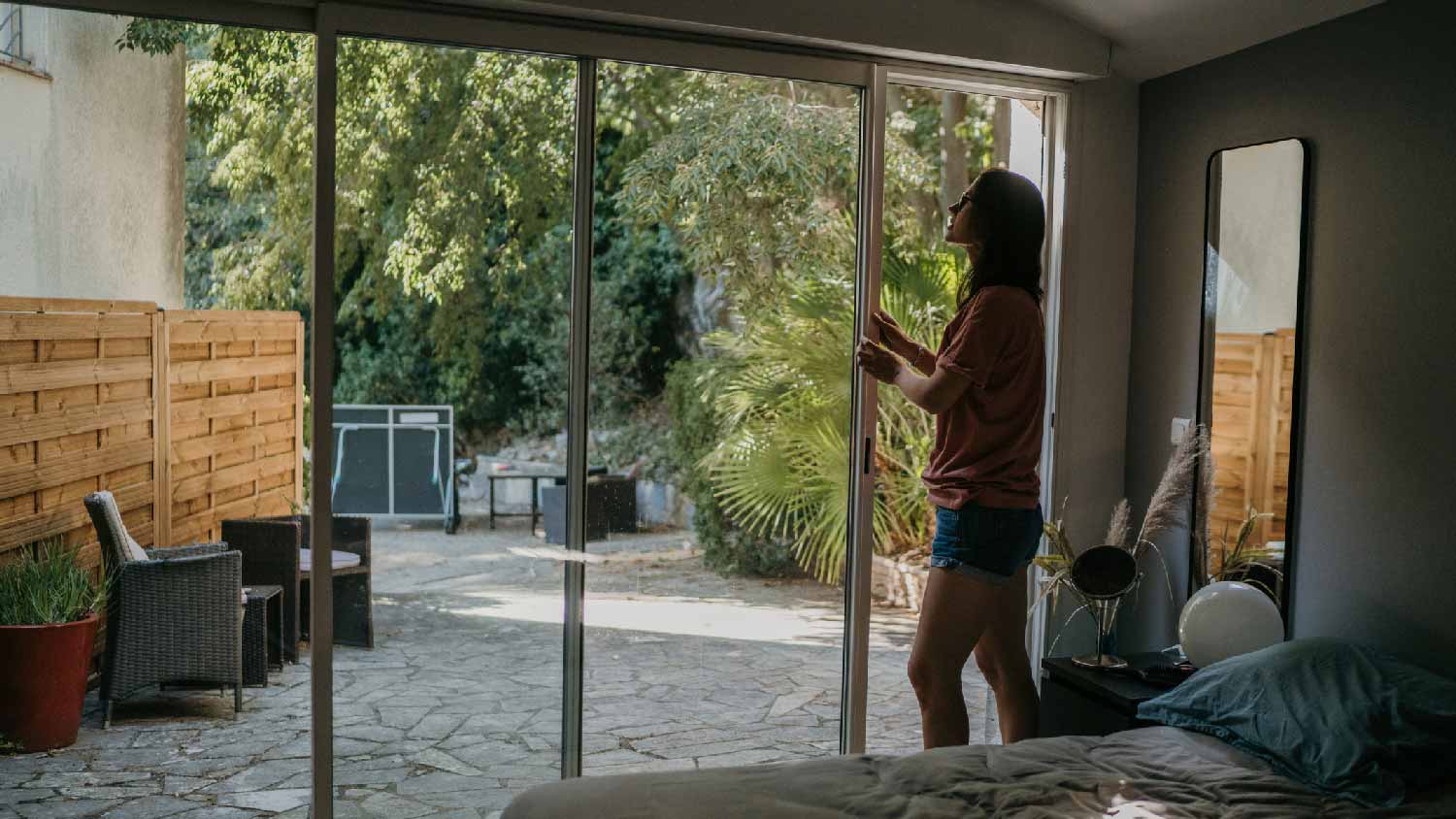 A woman opening a sliding glass door