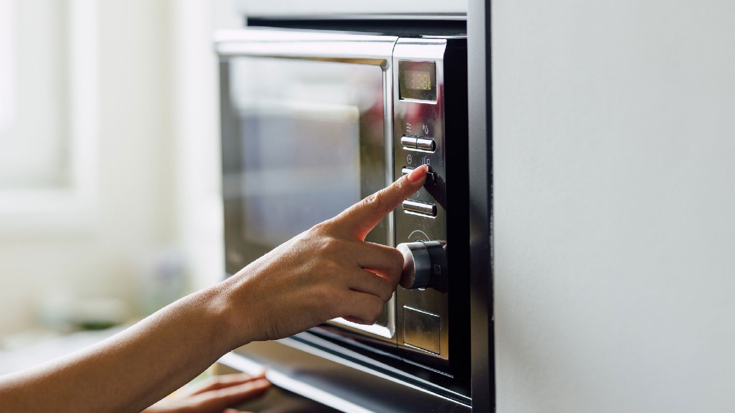 A woman operating a microwave