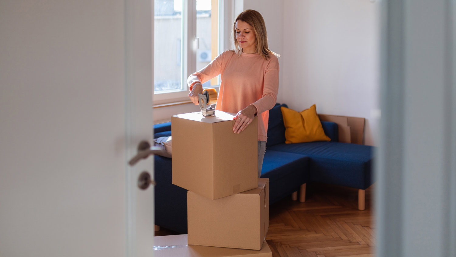 woman closing and packing boxes in apartment