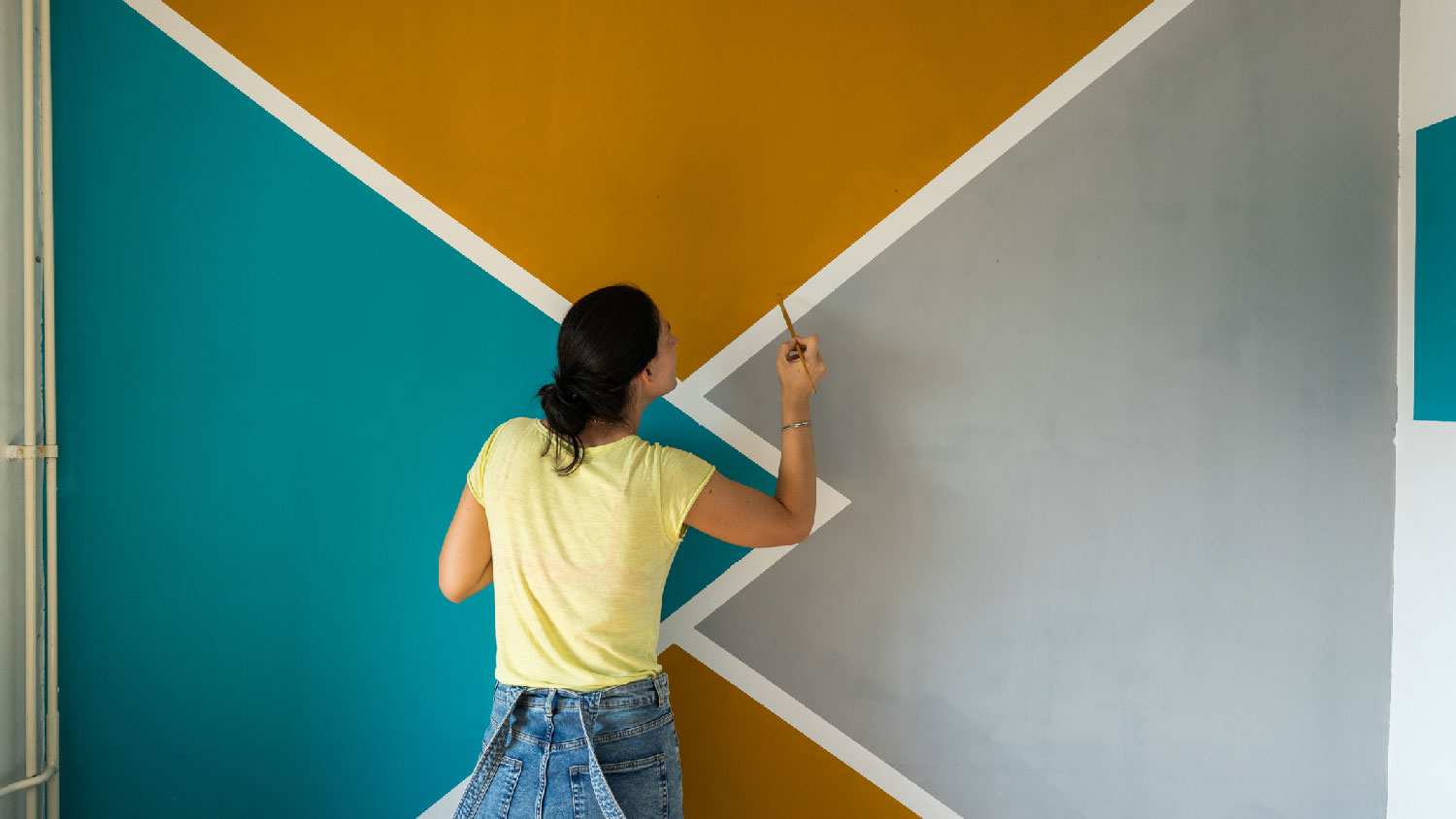 A woman painting an accent wall