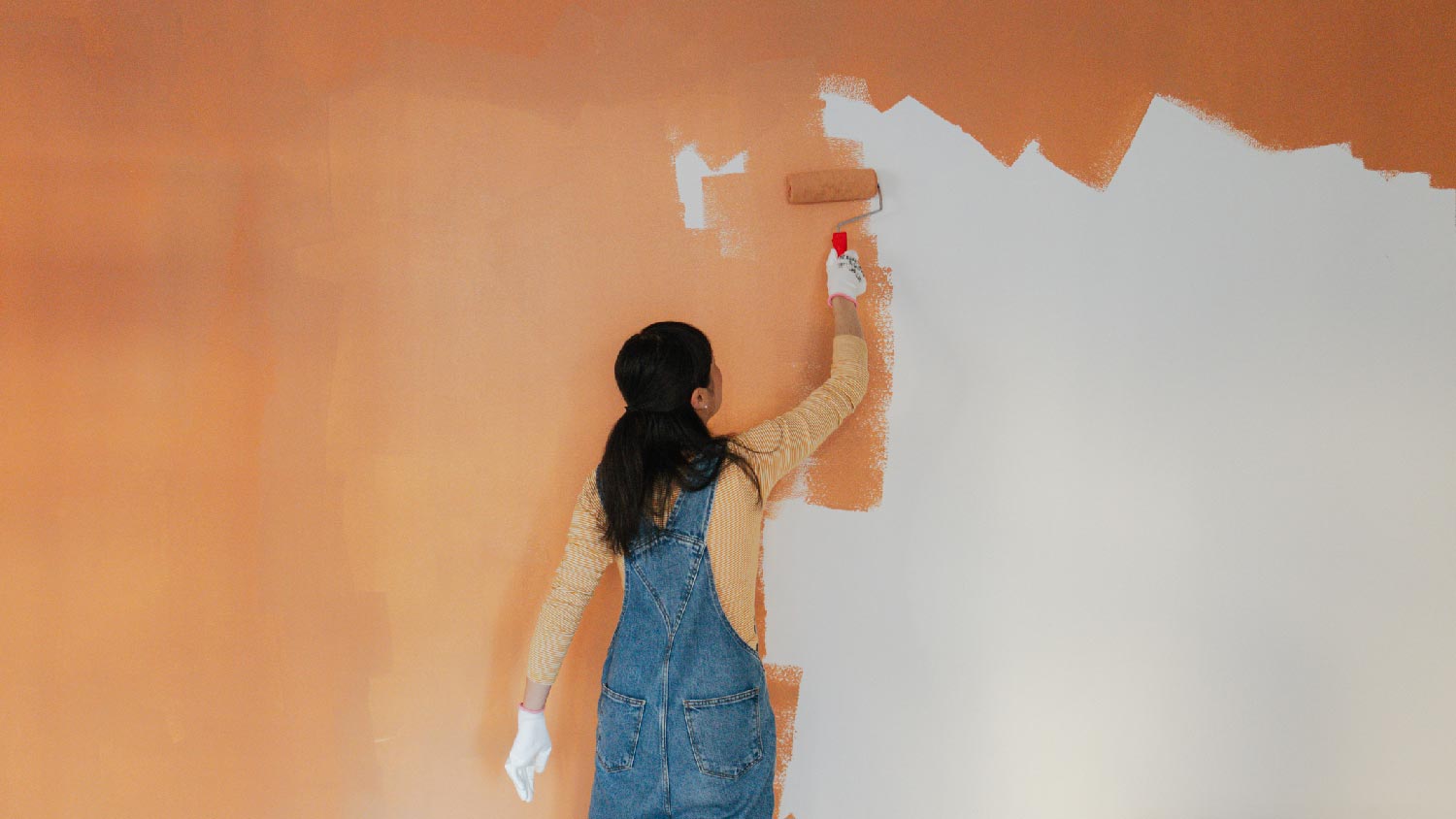 A woman painting an accent wall