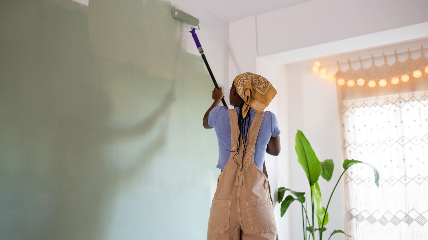 woman painting living room green  