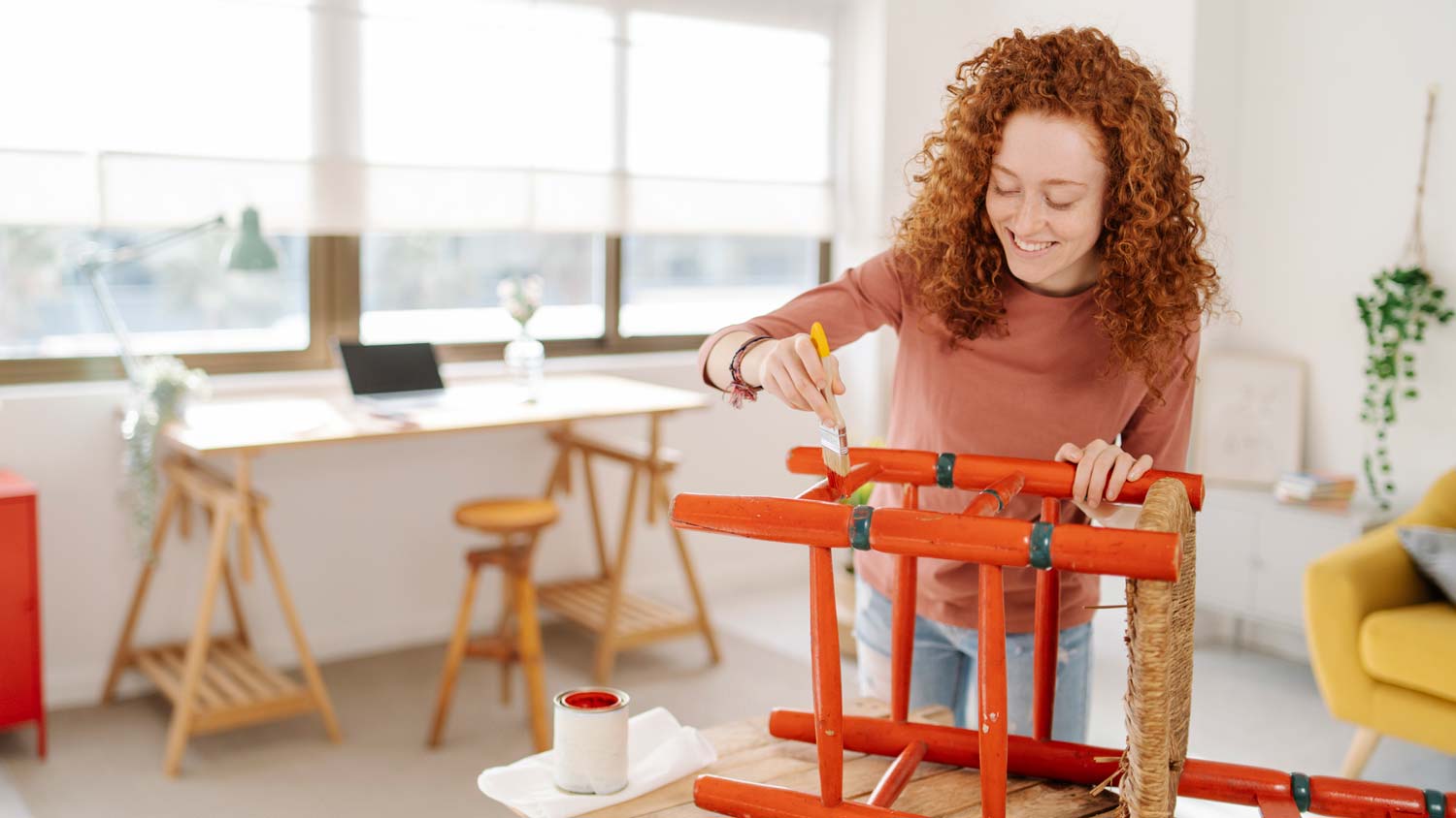 A woman painting a wooden chair