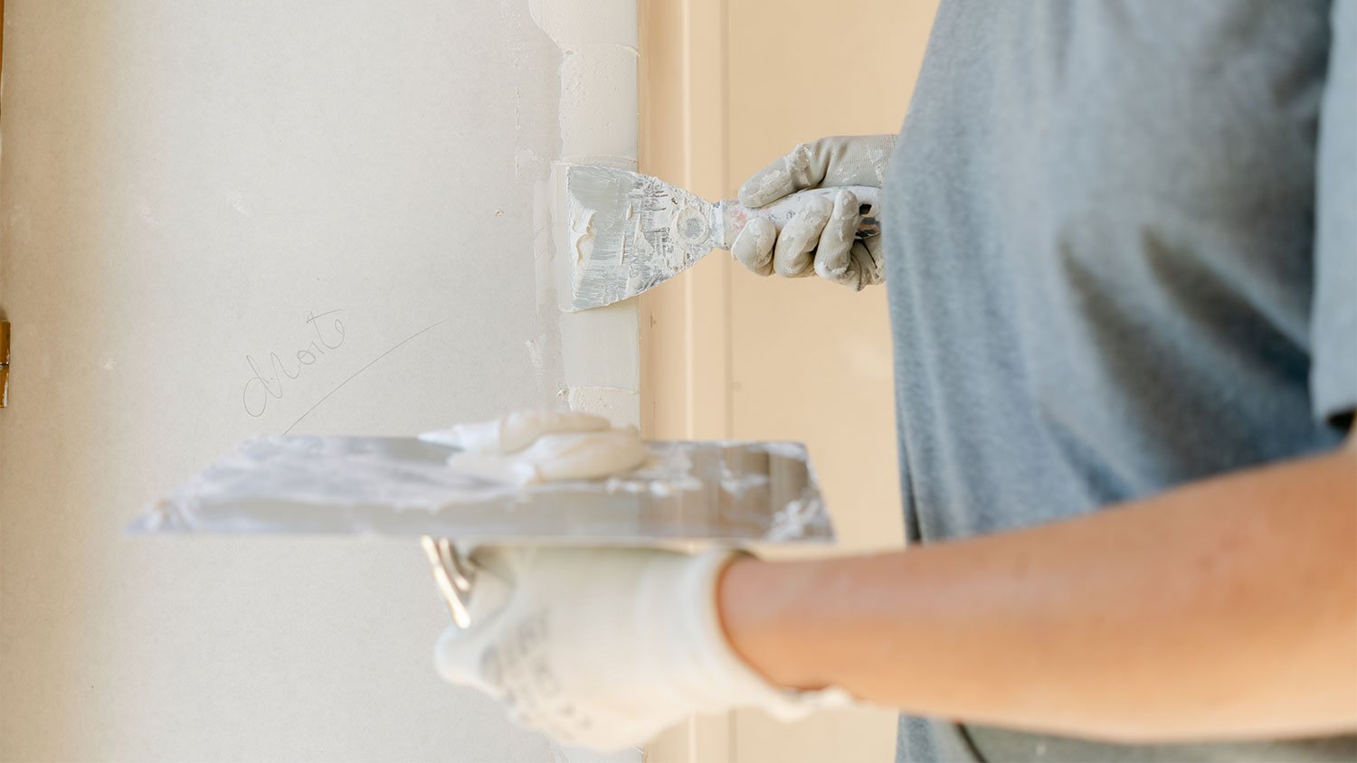 woman applying plaster on wall