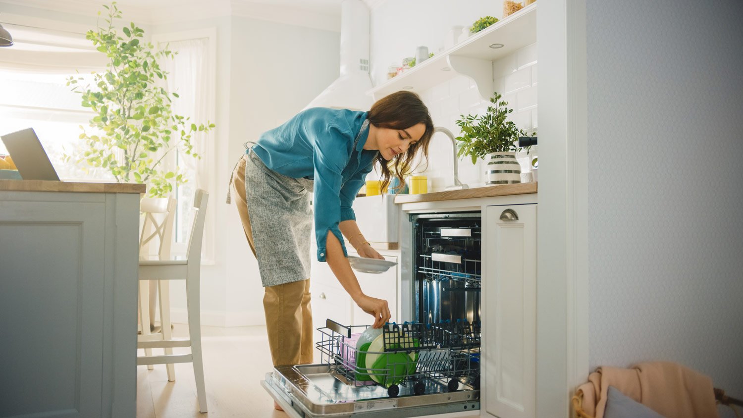 A woman putting dished in the dishwasher