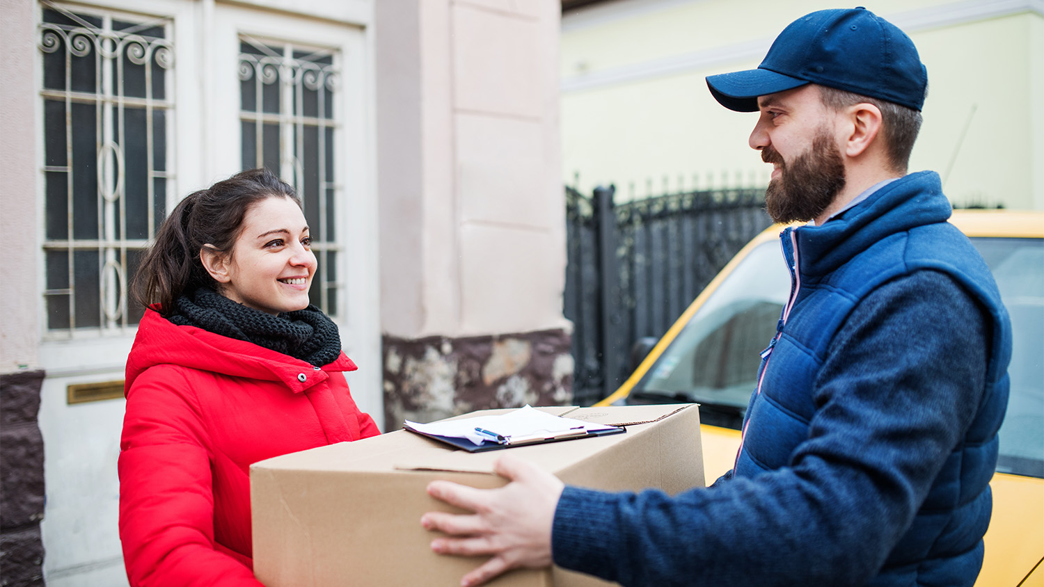 woman accepting package from mail carrier 