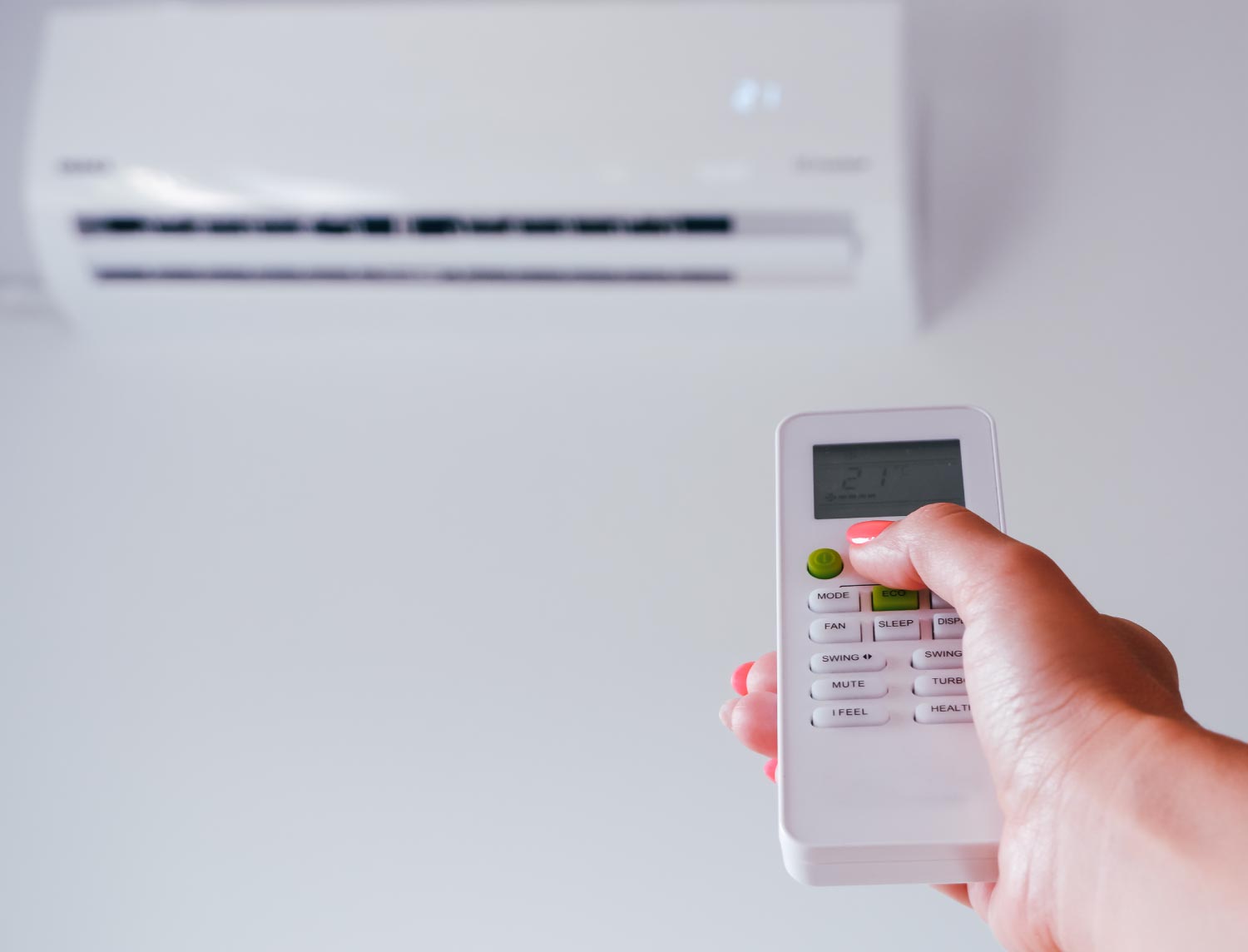 A woman holds a remote control from an air conditioner