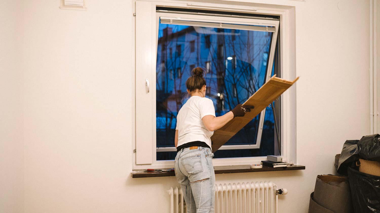 A woman removing an old window