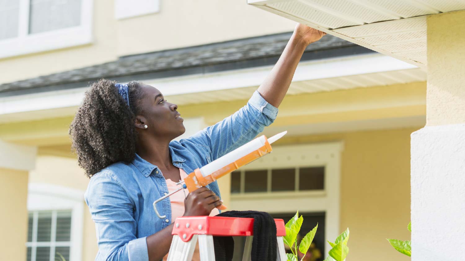 A woman repairing leaks with caulk