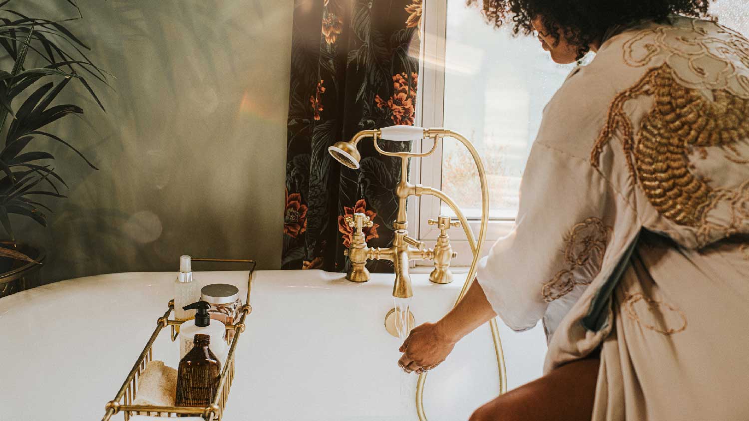 A woman sitting on the deck of a bathtub