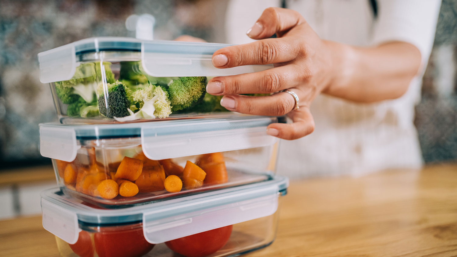 A woman storing vegetables in glass containers