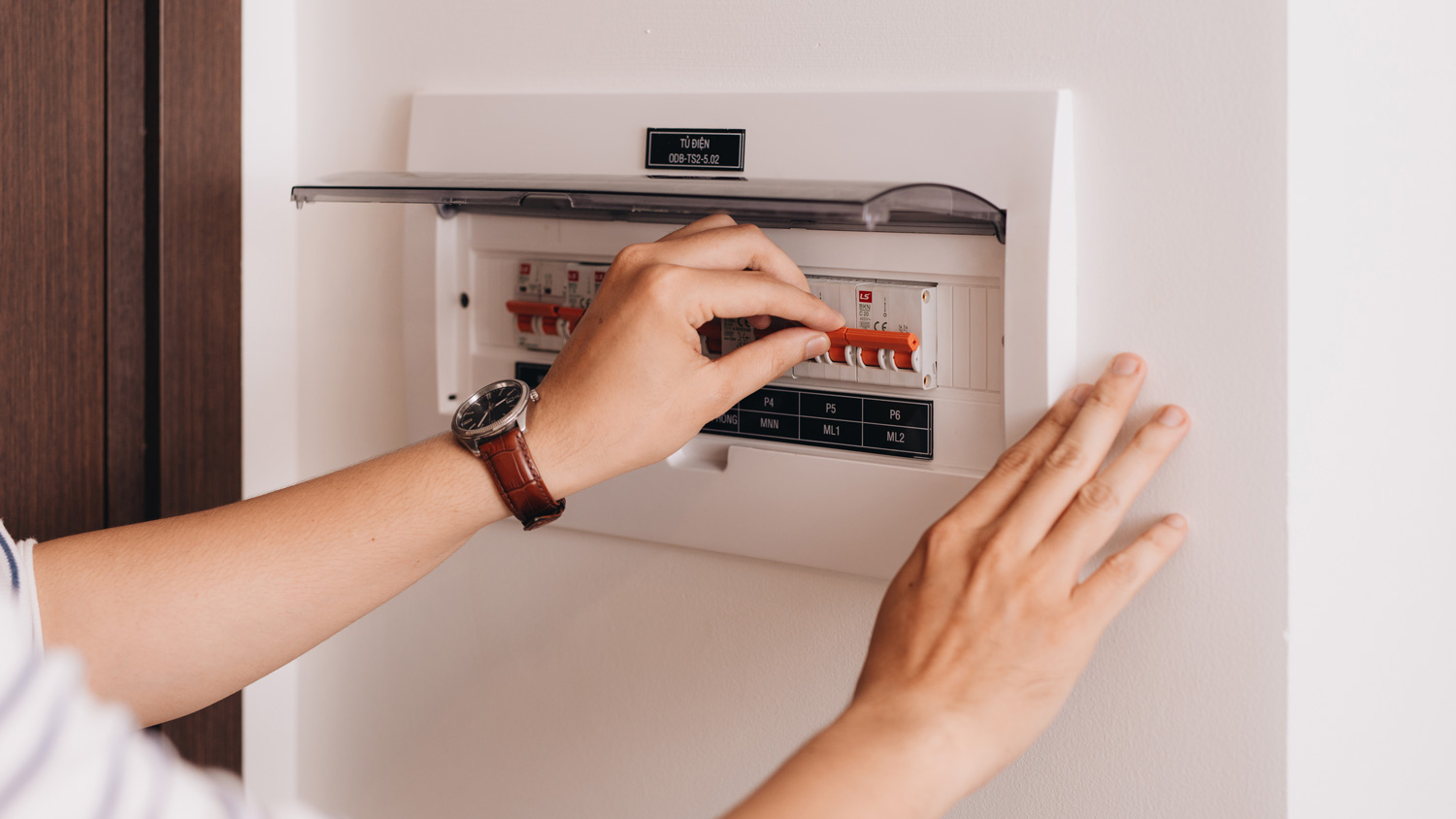 Detail of a woman switching on a circuit breaker