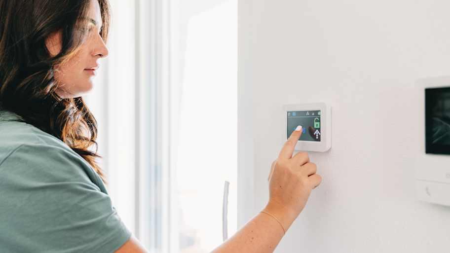 woman touching a control pad for home automation