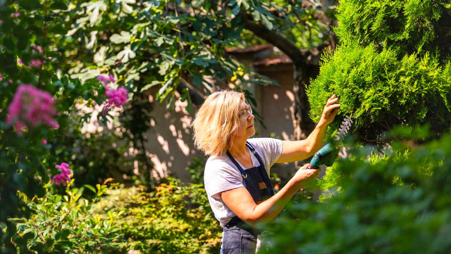 A woman trimming trees in her backyard