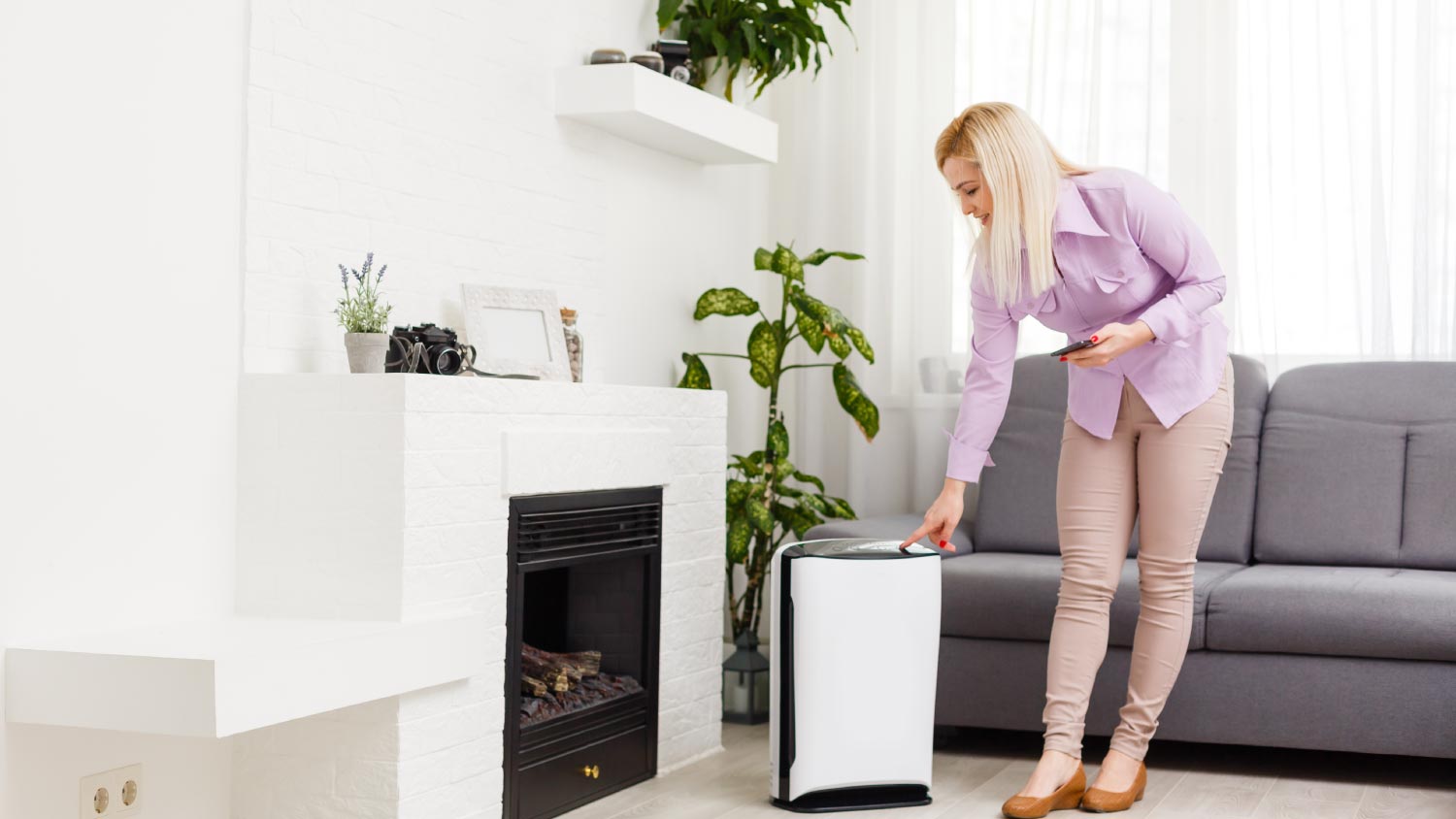 A woman turning on the air purifier