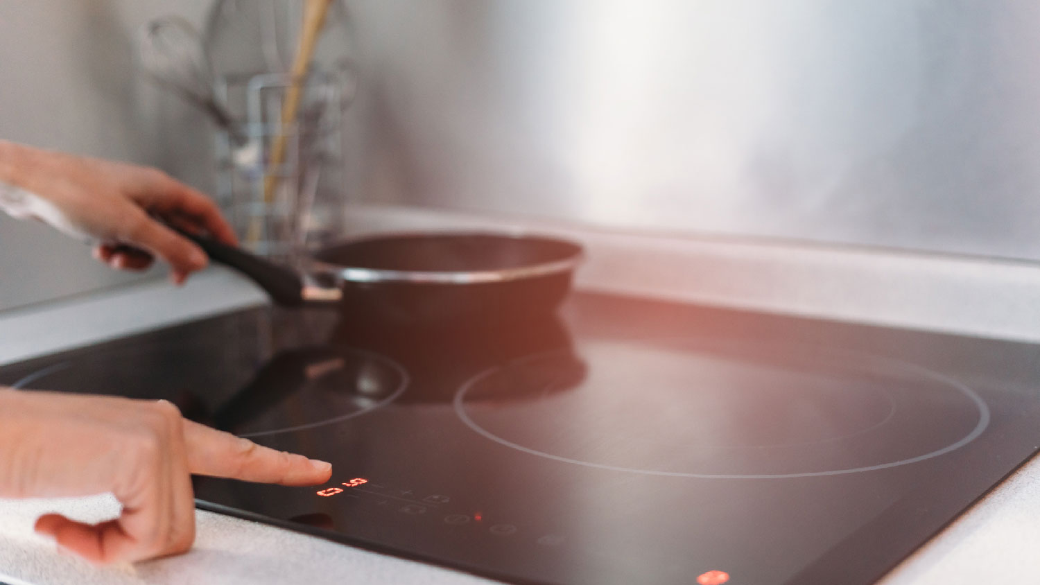 A woman turning on an electric stove