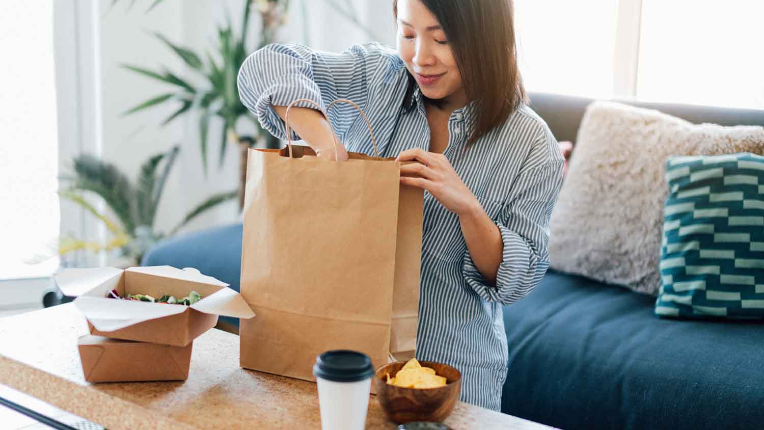 Woman unpacking takeout meal in the living room