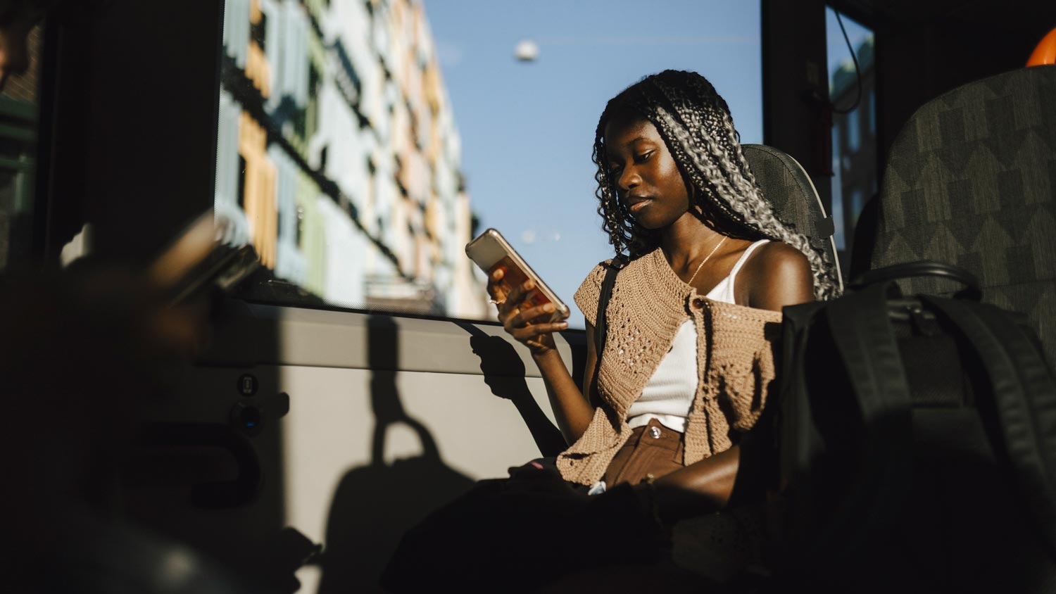 A woman using her phone in a public bus