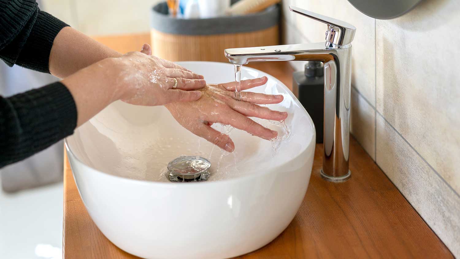 Woman washing hands in bathroom sink