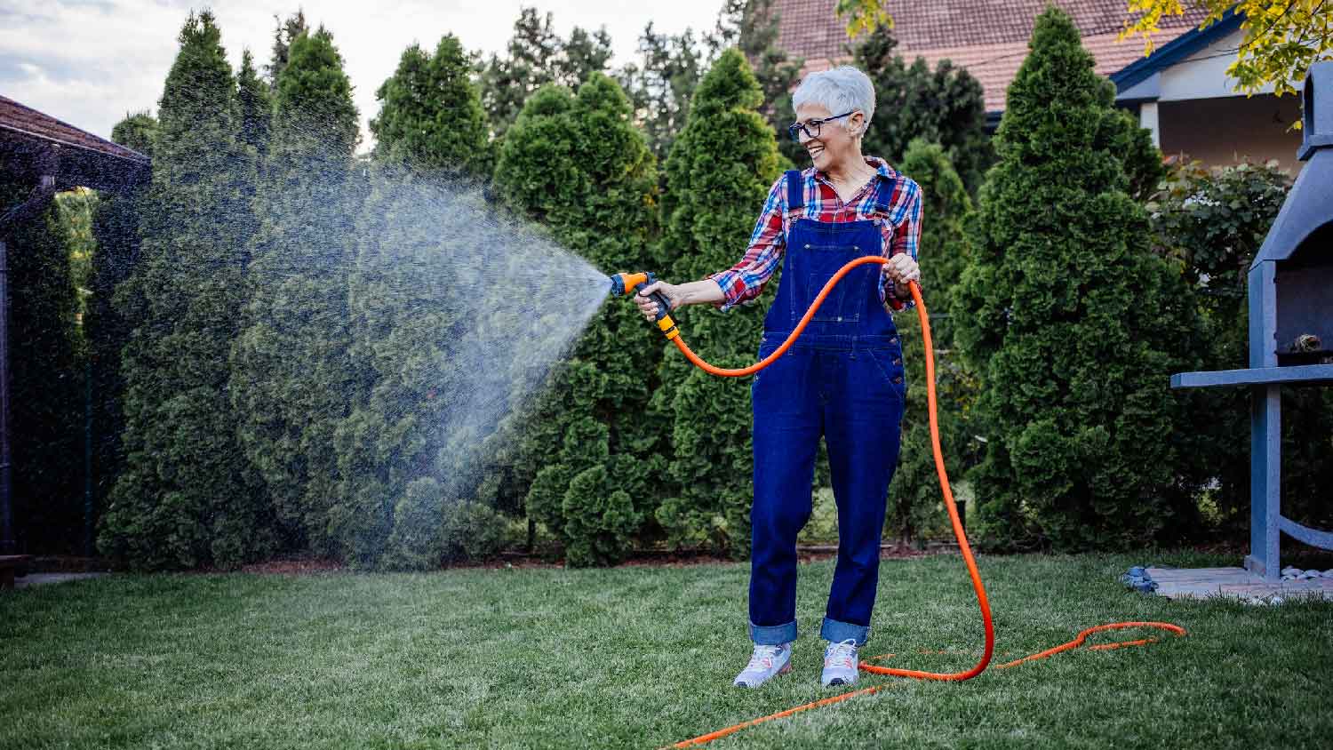 A woman watering the lawn