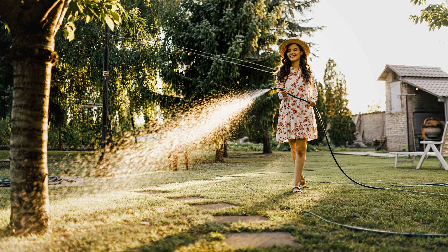 A woman watering the lawn with a hose
