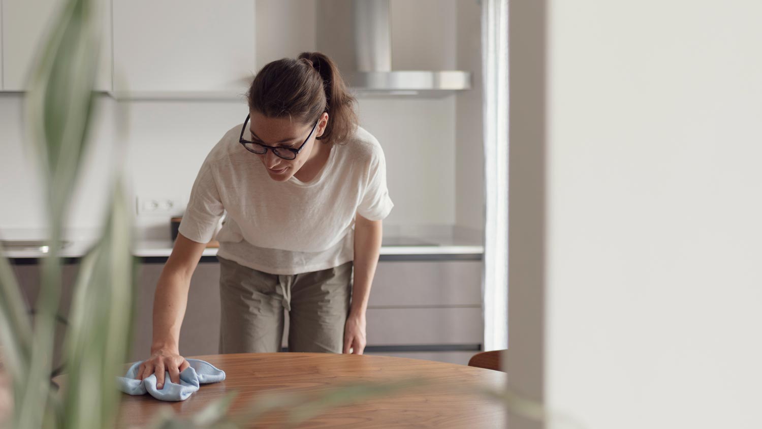 A woman wiping a wooden table